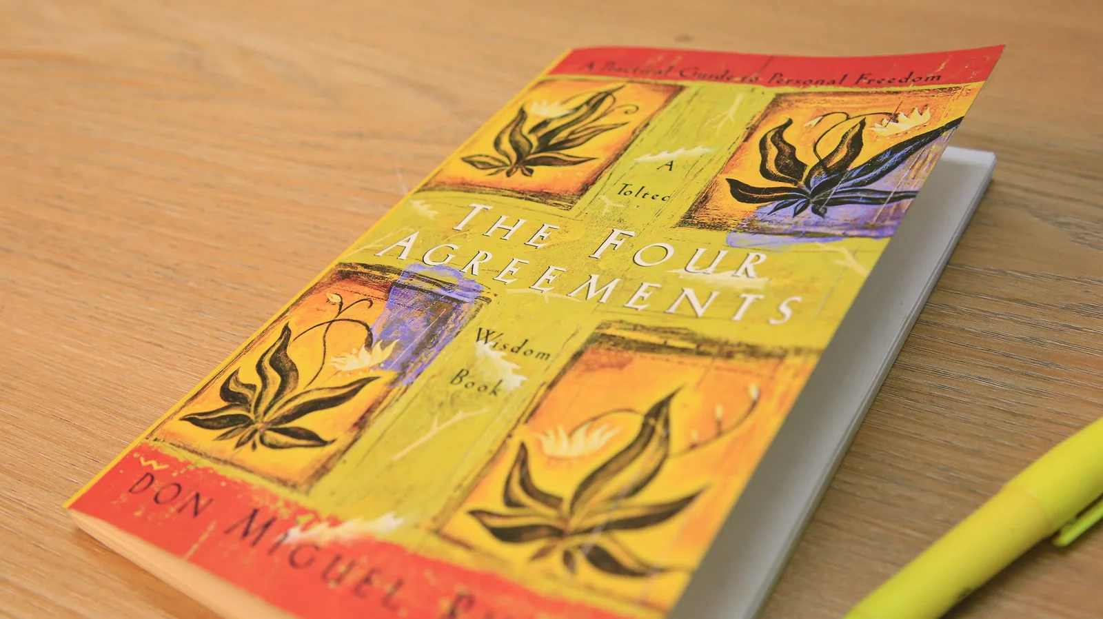 Kamil Hassan’s copy of The Four Agreements by Don Miguel Ruiz on a wooden table