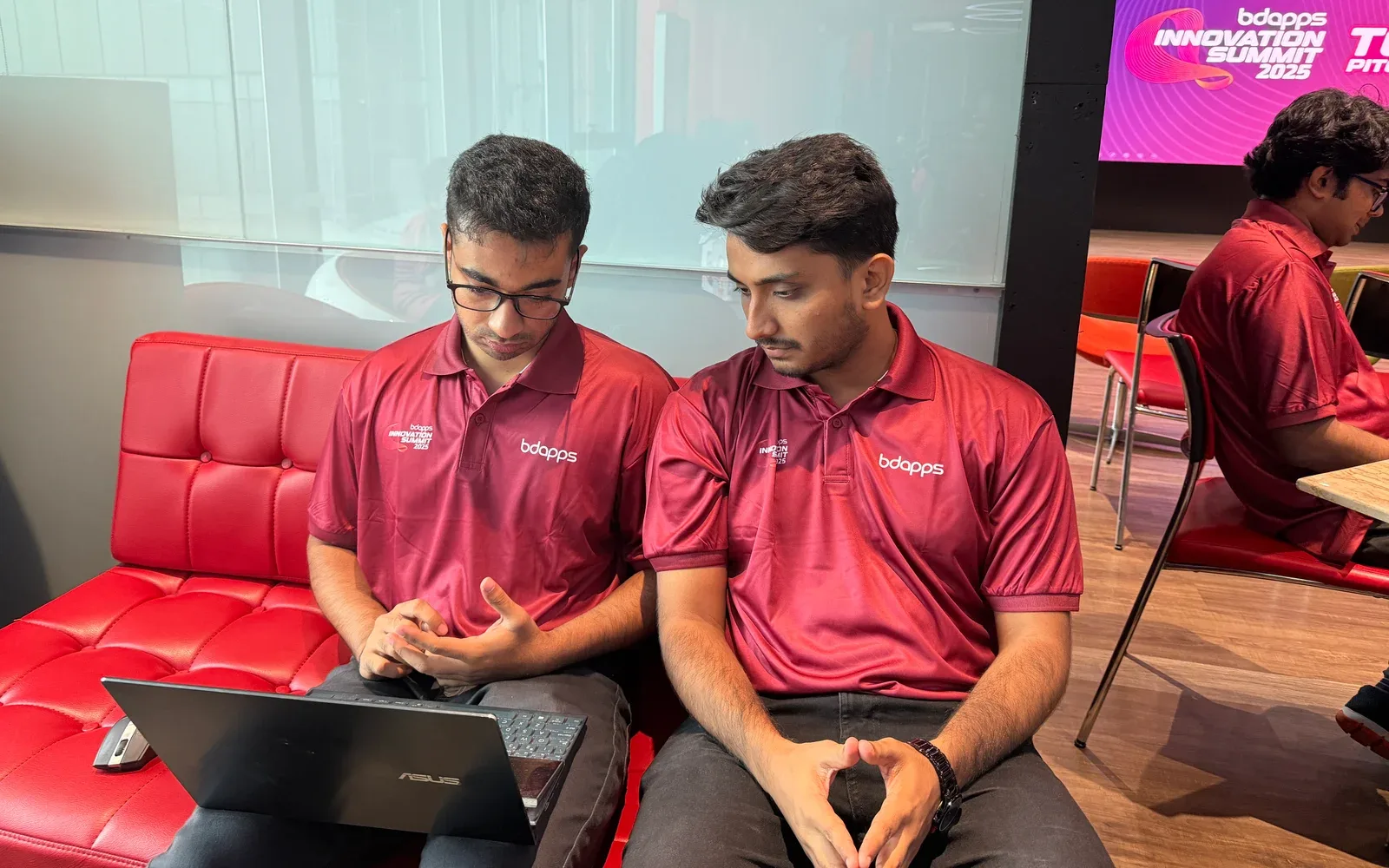 Kamil Hassan discussing ideas with teammates at the bdapps Innovation Summit